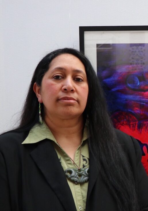 Maakarita Paku, woman with long hair standing in front of artwork