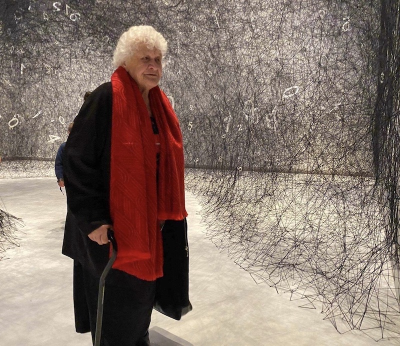 Elderly woman standing in an art exhibition at museum
